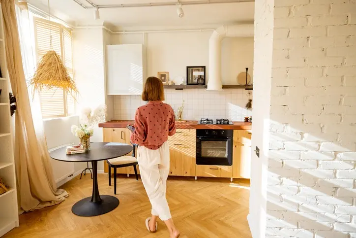 Beneficios de vivir en un espacio compacto y eficiente Mujer en su apartamento