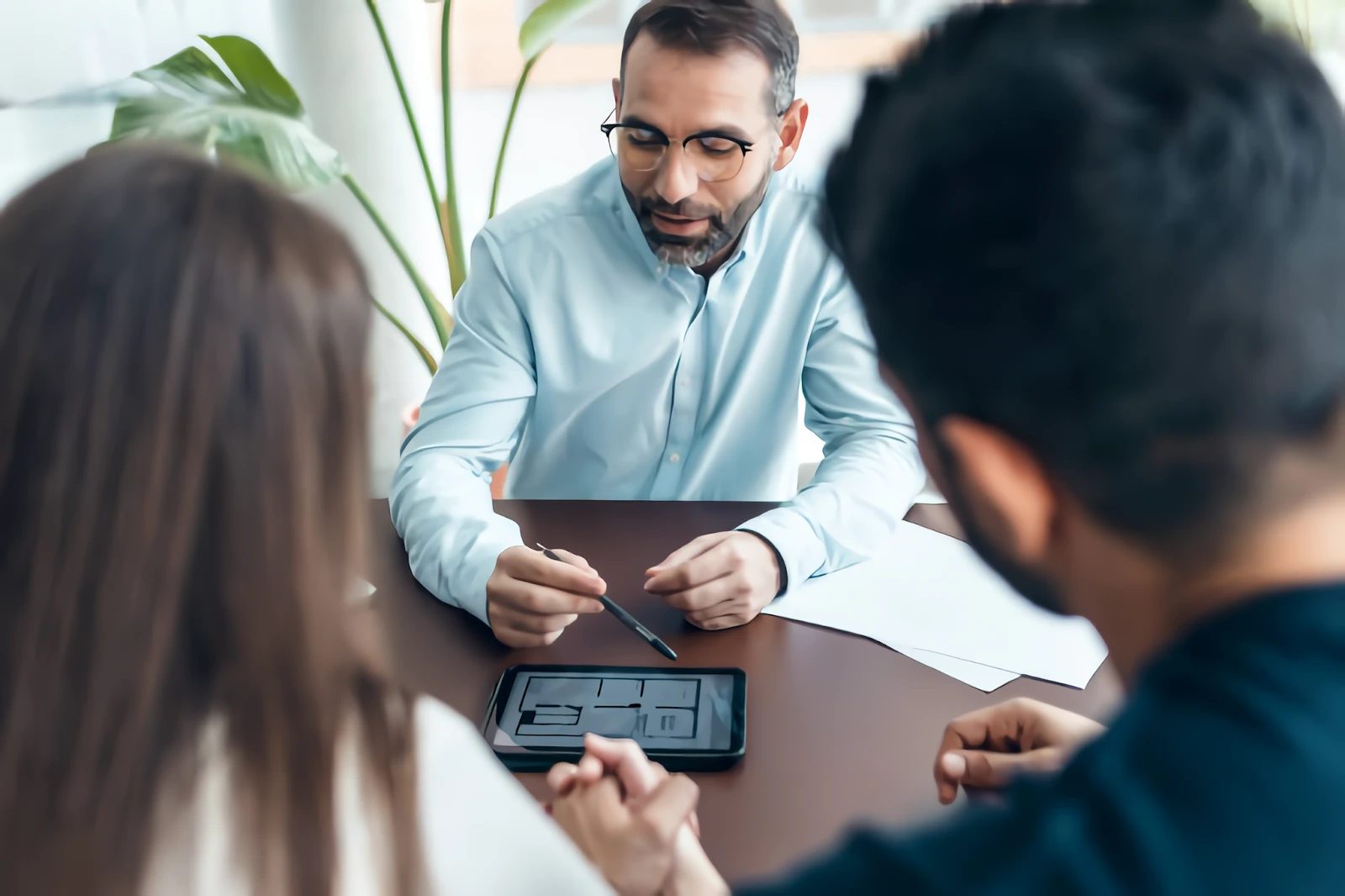 Agente inmobiliario atendiendo a una pareja