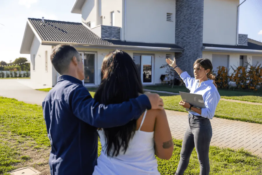 Agente inmobiliaria mostrando una casa a una pareja