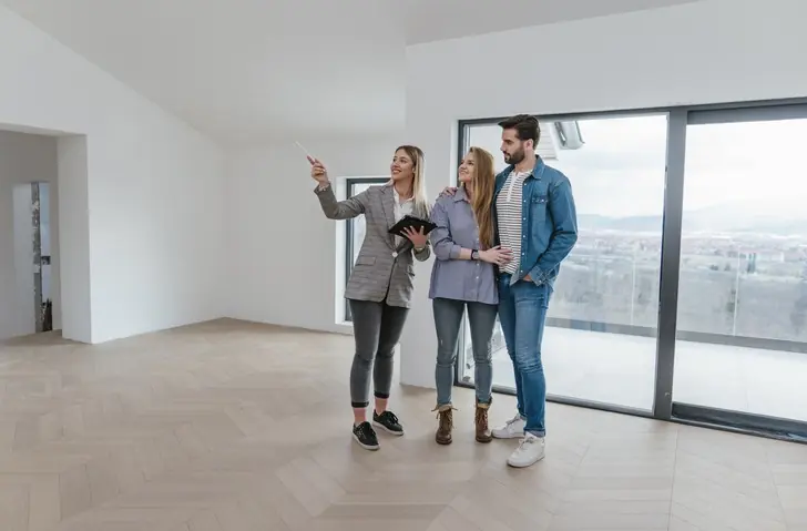 Beneficios de invertir en vivienda con OIKOS Inmobiliaria Personas viendo un apartamento