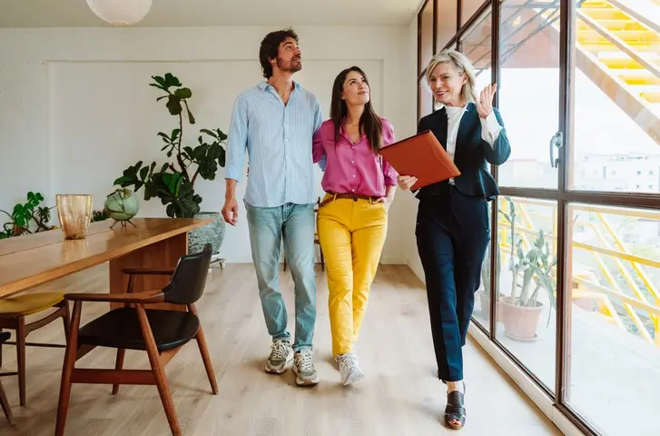 Personas viendo un inmueble con una agente inmobiliaria