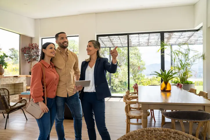 Agente inmobiliaria mostrando inmuebles a sus clientes
