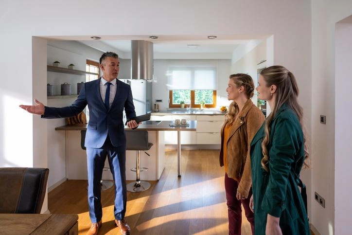 Vendedor inmobiliario y dos mujeres