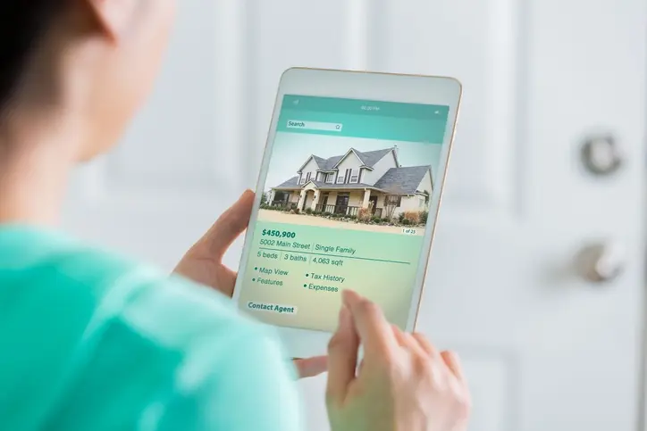 Persona buscando propiedades en una página inmobiliaria