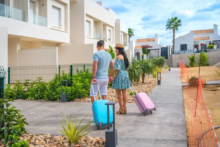 Inmuebles para renta corta y flexible Pareja con maletas de viaje