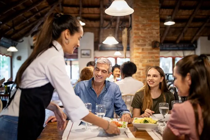 Tendencias de consumo que impulsan nuevos restaurantes Mesera atendiendo una mesa