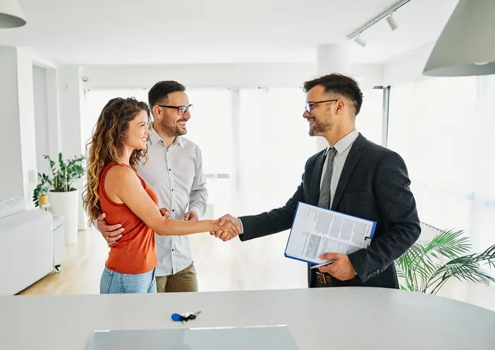 ¿Cómo OIKOS Inmobiliaria puede ayudarte a vender más rápido? Pareja hablando con agente inmobiliario