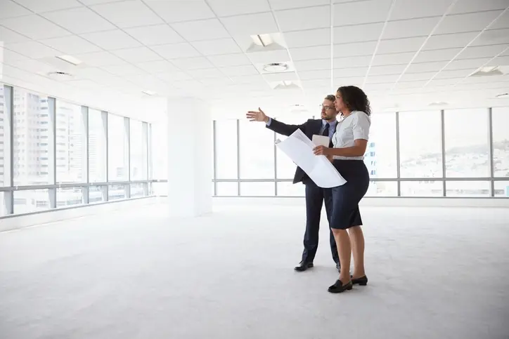 Espacios híbridos: qué buscan las empresas al comprar oficinas este año Personas estudiando planos