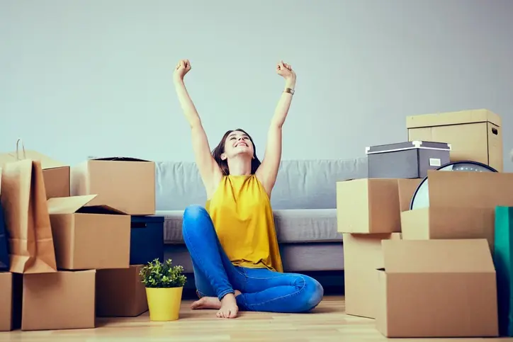 Servicios y características que debe tener un apartaestudio para estudiantes y profesionales Mujer feliz en su nuevo apartaestudio