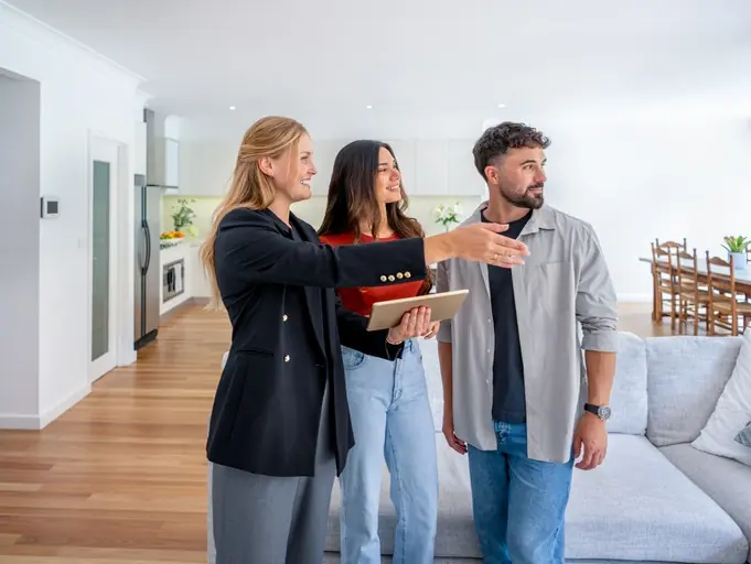 Agente inmobiliaria mostrando un inmueble a una pareja