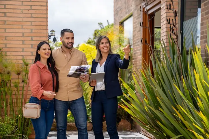 Rol de la inmobiliaria en la compra segura de vivienda Agente inmobiliaria mostrando un inmueble