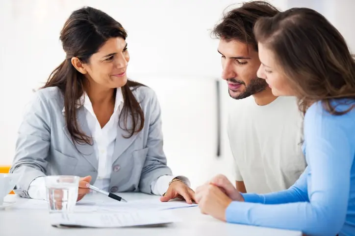Agente inmobiliaria mostrando contratos a una pareja