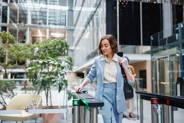 Espacios híbridos: qué buscan las empresas al comprar oficinas este año Mujer entrando al edificio