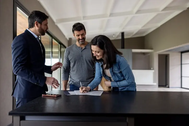 Recomendaciones para evitar fraudes inmobiliarios en Bogotá Mujer firmando un documento