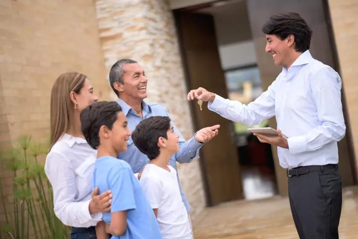 ¿Por qué confiar la venta de tu inmueble a OIKOS Inmobiliaria? Familia feliz con las llaves de su casa