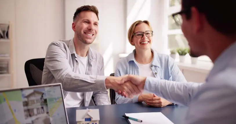 Pareja hablando con asesor inmobiliario