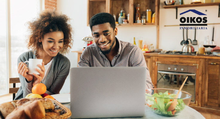 Pareja eligiendo su inmueble desde el portal online de OIKOS Inmobiliaria.